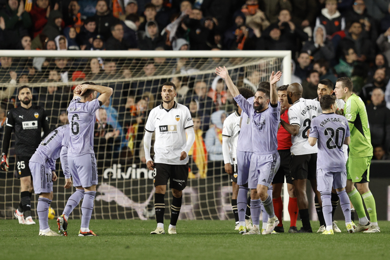 Los jugadores del Real Madrid protestan al colegiado Gil Manzano el gol anulado en el último momento del encuentro contra el Valencia. (Foto: EFE)