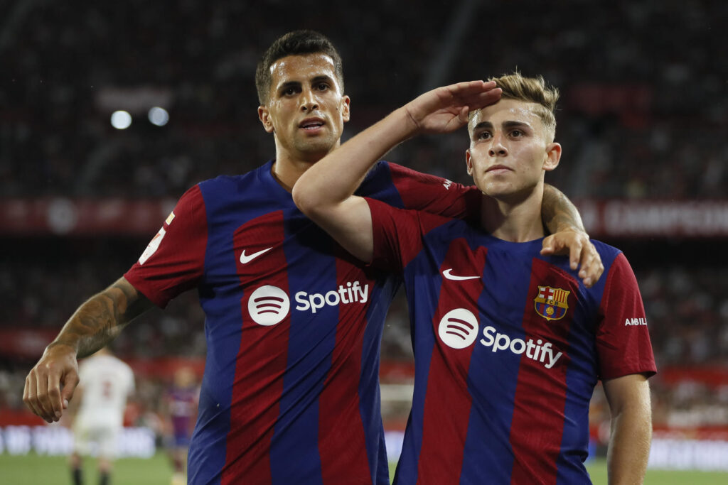 El delantero del FC Barcelona Fermín López (d) celebra su gol durante el último partido de LaLiga que Sevilla FC y FC Barcelona disputaron en el estadio Ramón Sánchez-Pizjuán, en Sevilla. EFE/José Manuel Vidal
