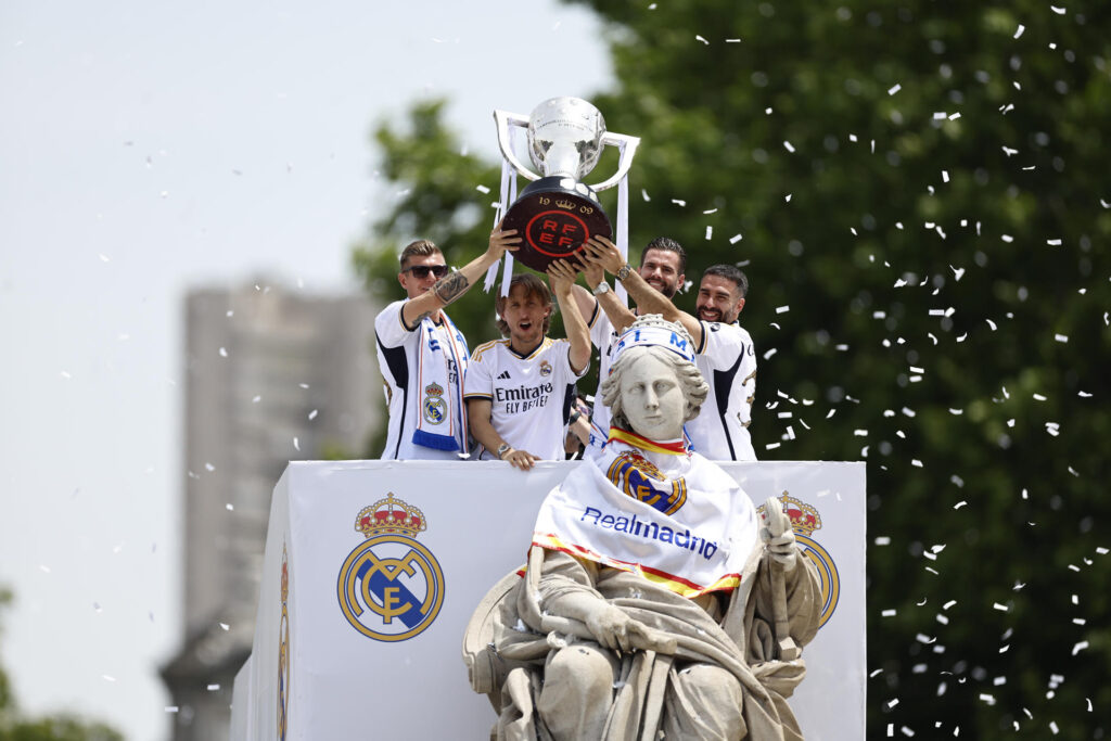 El capitán del Real Madrid, Nacho Fernández, junto a los jugadores, Toni Kroos (i), Luka Modric (2i) y Dani Carvajal levantan la copa junto a la diosa Cibeles durante la celebración con aficionados de la trigésimo sexta Liga. EFE/Rodrigo Jiménez