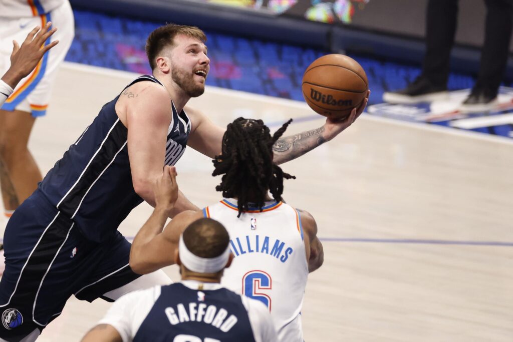 El base de los Mavericks, Luka Doncic (i), supera al guardia de Oklahoma City Thunder, Luguentz Dort (d), durante un pasaje del tercer juego de los 'playoffs' de la ronda semifinal de la Conferencia Oeste de la la NBA jugado este sábado que dejó con ventaja de 2-1 a la franquicia de Dallas ante su público con otra destacada presentación del esloveno. EFE/ADAM DAVIS