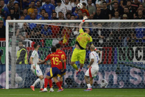 GELSENKIRCHEN (ALEMANIA), 20/06/2024.- El guardameta de la selección italiana, Gianluigi Donnarumma (2d), despeja un balón rematado por el centrocampista de España, Pedri, durante el encuentro correspondiente a la fase de grupos de la Eurocopa 2024 que España e Italia disputan hoy jueves en Gelsenkirchen (Alemania). EFE/J.J Guillén.