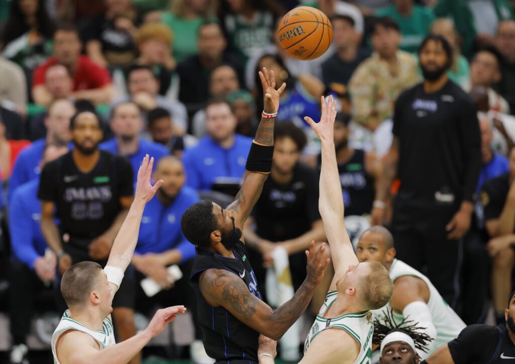 El jugador de los Dallas Mavericks, Kyrie Irving (C) contra los jugadores de los Boston Celtics, Kristaps Porzingis (d) y Sam Hauser (i). EFE/EPA/CJ GUNTHER SHUTTERSTOCK FUERA