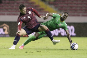 Manfred Ugalde (i) de Costa Rica disputa el balón con Tyrese Shade de San Cristóbal y Nieves en un partido de  de las eliminatorias de Concacaf para el Mundial 2026. EFE/ Jeffrey Arguedas