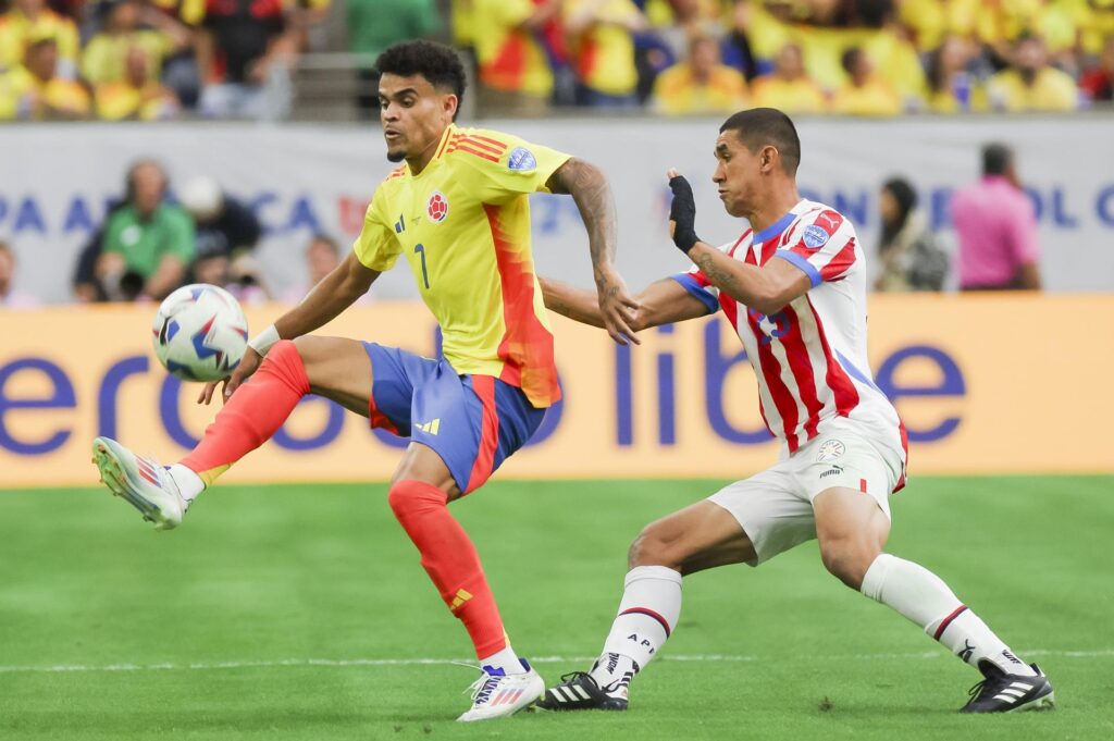 El delantero colmbiano Luis Díaz (i) fue registrado este lunes, 24 de junio, al disputar un balón con el defensor paraguayo Gustavo Velázquez (d), durante el primer partido del grupo D de la Copa América, en el estadio NRG de Houston (Texas, EE.UU.). EFE/Leslie Plaza