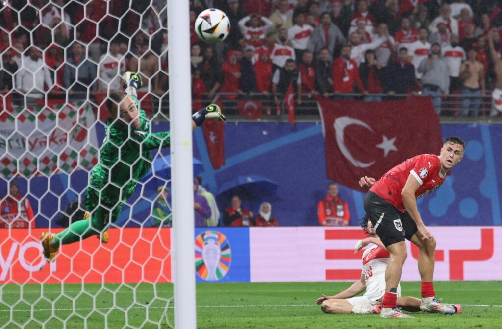 Leipzig (Germany), 02/07/2024.- Turkey goalkeeper Mert Gunok (L) saves a shot from Christoph Baumgartner of Austria (R) during the UEFA EURO 2024 Round of 16 soccer match between Austria and Turkey, in Leipzig, Germany, 02 July 2024. (Alemania, Turquía) EFE/EPA/CHRISTOPHER NEUNDORF