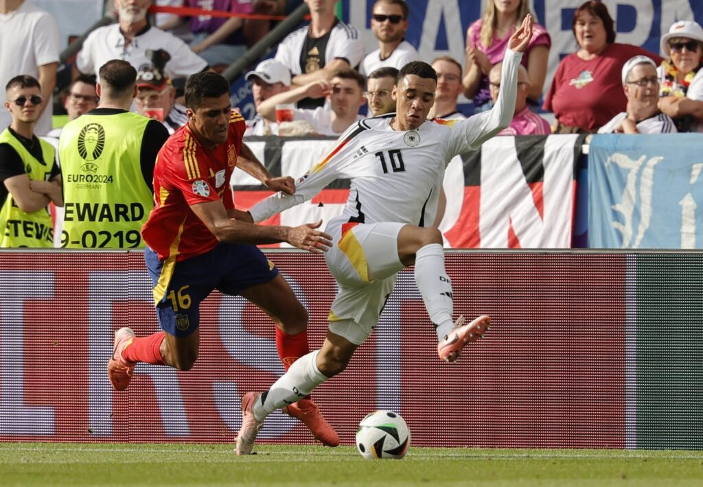 El español Rodri (I) y el alemán Jamal Musiala en acción durante el partido de cuartos de la Eurocopa 2024 entre España y Alemania en Stuttgart, Alemania EFE/EPA/RONALD WITTEK