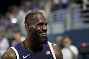 El alero de Estados Unidos Lebron James sonría tras la victoria de su equipo ante Serbia en el partido del torneo de baloncesto de París 2024 celebrado este domingo en el estadio Pierre Mauroy. (París 2024) EFE/ALEX PLAVEVSKI