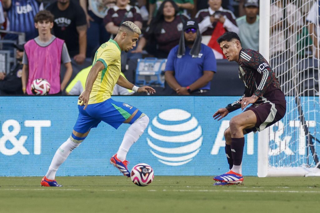 El defensa brasileño Yan Couto (i) intenta regatear al mexicano Edson Alvarez (d) durante un partido amistoso. EFE/Adam Davis