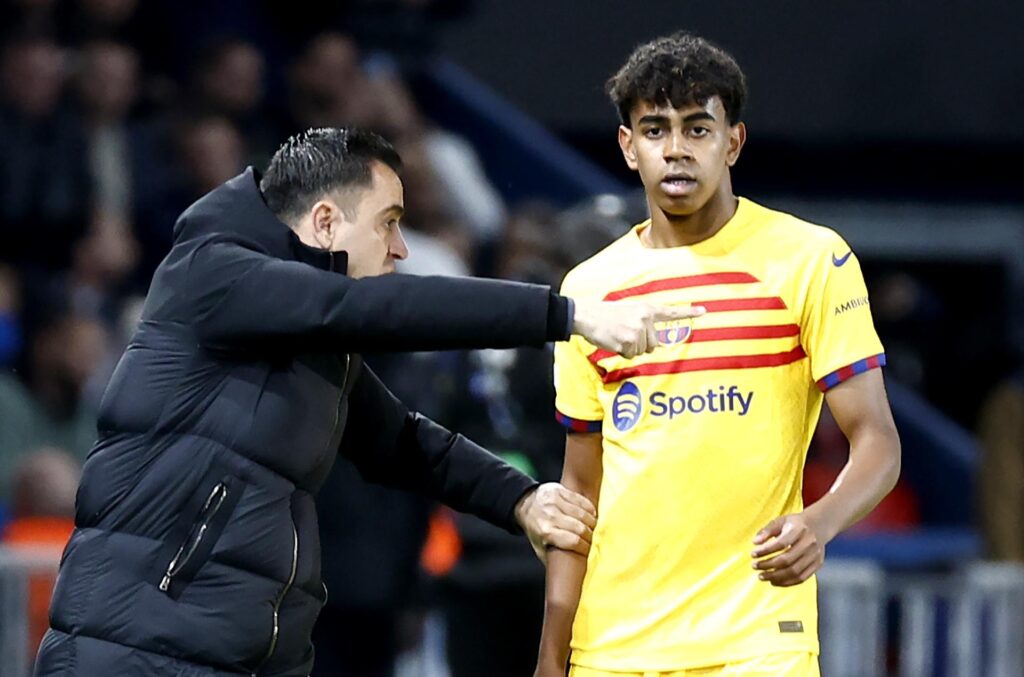 El entrenador del Barcelona Xavi Hernandez (I) dialoga con su jugador Lamine Yamal durante el partido de ida de cuartos de final de la UEFA Champions League en el Parque de los Príncipes de París. EFE/EPA/MOHAMMED BADRA