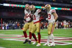 MEX487. CIUDAD DE MÉXICO (MÉXICO), 21/11/2022.- (i-d) Jake Brendel, Brandon Aiyuk y Christian McCaffrey de los San Francisco 49ers celebran hoy un touchdown contra los Arizona Cardinals, durante un juego por la semana 11 de la NFL en el Estadio Azteca en Ciudad de México (México). EFE/Isaac Esquivel
