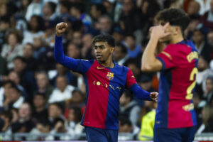 El delantero del FC Barcelona Lamine Yamal celebra tras anotar el tercer gol de su equipo durante el partido de la jornada 11 de LaLiga EA Sports entre el Real Madrid y el FC Barcelona, este sábado en el estadio Santiago Bernabéu, en Madrid. EFE/ Kiko Huesca