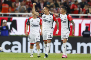 AME005. GUADALAJARA (MÉXICO), 21/11/2024.- Uros Durdevic (c) junto a Luis Ricardo Reyes de Atlas celebran un gol este jueves, durante un partido de reclasificación del torneo apertura 2024 de la liga del fútbol mexicano entre Guadalajara y Atlas, en el Estadio Akron, en la ciudad de Guadalajara, Jalisco (México). EFE/ Francisco Guasco