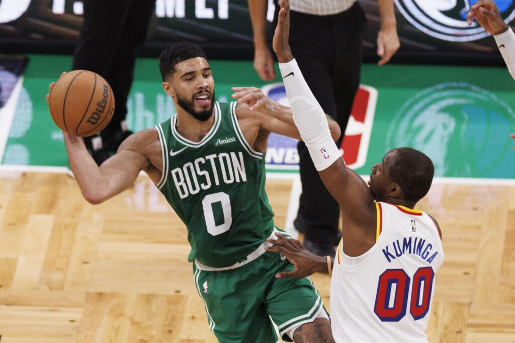 El alero de los Boston Celtics Jayson Tatum (I) pasa el balón ante la oposición del alero de los Golden State Warriors, Jonathan Kuminga (D), durante el partido de baloncesto de la NBA entre los Boston Celtics y los Golden State Warriors en Boston, Massachusetts. EFE/EPA/CJ GUNTHER SHUTTERSTOCK PROHIBIDO