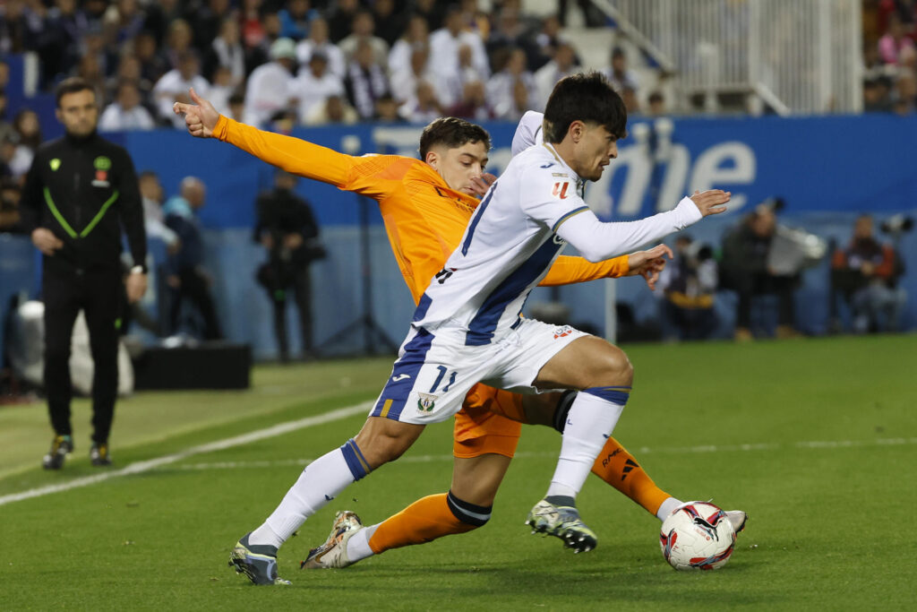 El delantero del Leganés, Juan Cruz (d), intenta llevarse el balón ante el centrocampista uruguayo del Real Madrid, Federico Valverde, durante el encuentro correspondiente a la jornada 14 de Laliga EA Sports disputado Leganés y Real Madrid en el estadio de Butarque, en Leganés. EFE / J.J. Guillen.