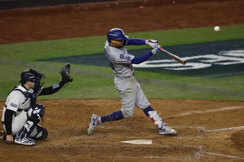 Mookie Betts de los Los Angeles Dodgers (d) conecta el elevado de sacrificio que da la ventaja por la carrera impulsada al jardín central durante la octava entrada del quinto juego de la Serie Mundial de las Grandes Ligas de Béisbol (MLB). EFE/EPA/CJ GUNTHER
