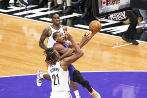 chai Agbaji (c) de los Toronto Raptors intenta una canasta con la oposición de Noah Clowney (abajo) de los Brooklyn Nets este jueves, durante un partido en el Scotiabank Arena en Toronto (Canadá). EFE/ Julio César Rivas