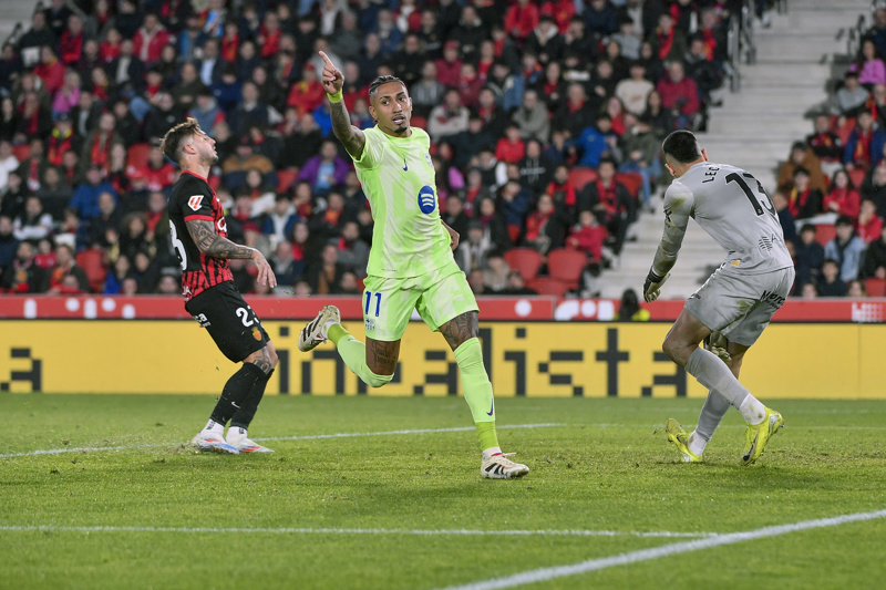 PALMA DE MALLORCA, 03/12/2024.- El delantero del Barcelona Raphinha (c) celebra tras marcar el tercer gol ante el Mallorca, durante el partido de la jornada 19 de LaLiga EA Sports que RCD Mallorca y FC Barcelona disputan este martes en el estadio de Son Moix. EFE/MIQUEL BORRÀS