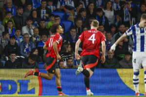 El delantero neerlandés del Manchester United Joshua Zirkzee (i) celebra con sus compañeros tras anotar el primer gol de su equipo este jueves, durante el primer partido de octavos de final de la Liga Europa, que enfrenta a la Real Sociedad y al Manchester United, en el Real Arena de San Sebastián. EFE/ Javier Etxezarreta