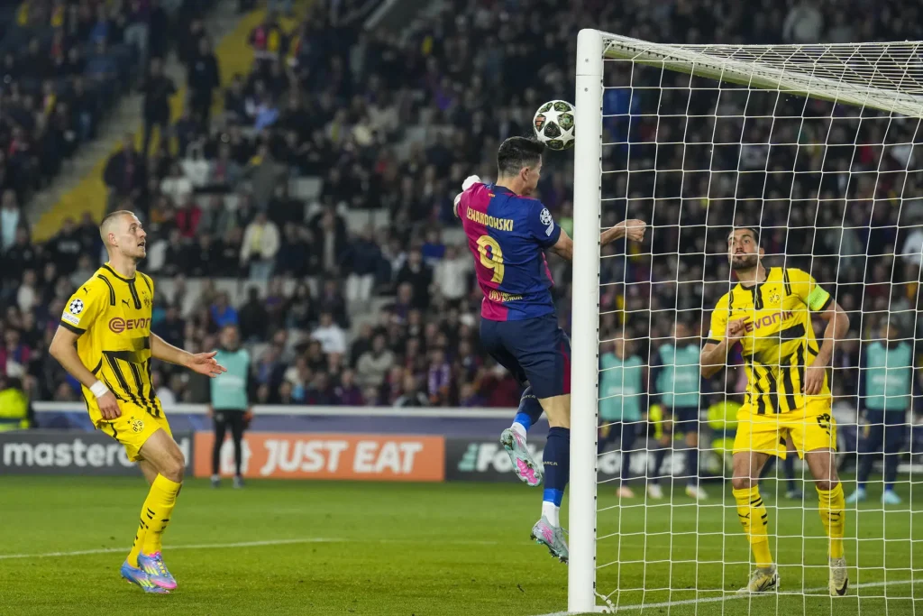 BARCELONA, 09/04/2025.- El delantero polaco del FC Barcelona, Robert Lewandowski (c), remata en la jugada que ha significado el segundo gol de su equipo durante el encuentro correspondiente a la ida de los cuartos de final de la Liga de Campeones que disputan hoy miércoles FC Barcelona y Borussia Dortmund en el Estadio Olímpico de Montjuic, en Barcelona. EFE / Alejandro García.