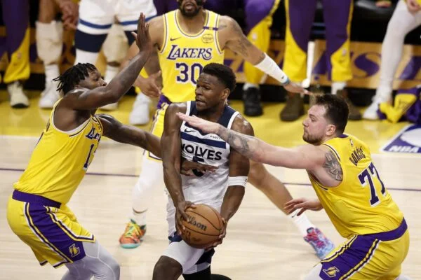 El escolta de los Minnesota Timberwolves, Anthony Edwards (C), entra a canasta defendido por lo jugadores de Los Angeles Lakers Dorian Finney-Smith (I) Luka Doncic (D). EFE/EPA/CAROLINE BREHMAN SHUTTERSTOCK FUERA