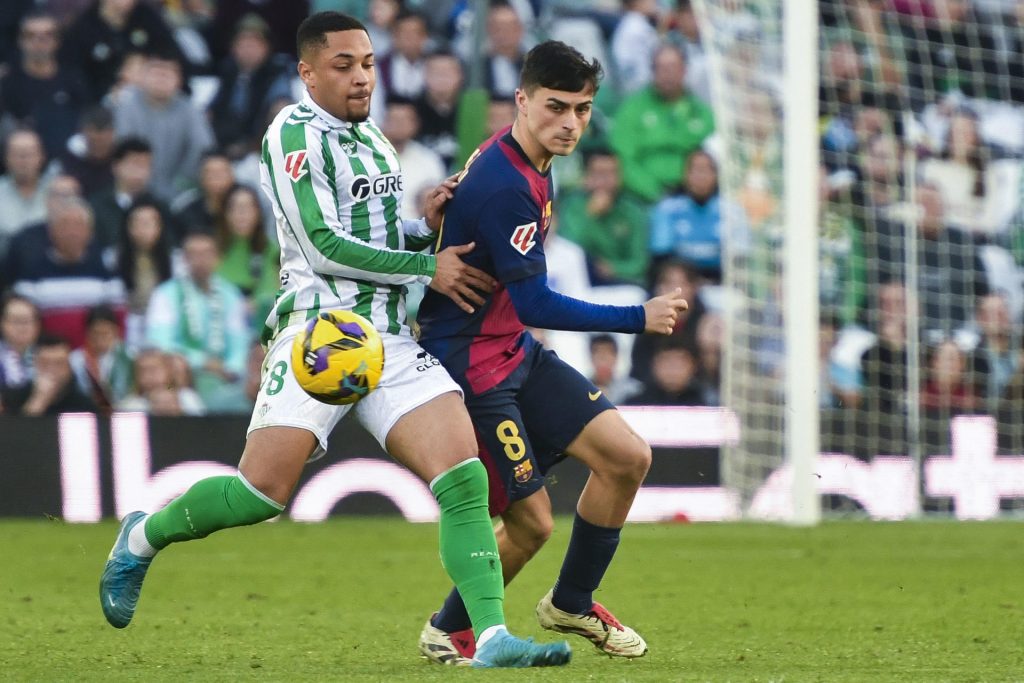 El centrocampista español del FC Barcelona Pedri (d) disputa un balón con el delantero brasileño del Betis Vitor Roque en el Estadio Benito Villamarín de Sevilla en foto de archivo de Raúl Caro. EFE