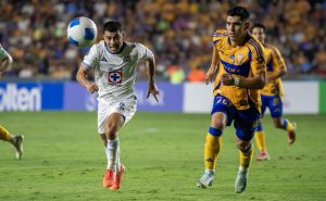 Jesús Angulo (d) de Tigres disputa el balón con Erik Lira de Cruz Azul este miércoles, en un partido de la semifinal de ida de la Concacaf Champions Cup entre Cruz Azul y Tigres, en el estadio Universitario de Monterrey (México). EFE/ Miguel Sierra