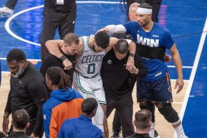 Jayson Tatumde(c), figura de Boston Celtics, abandona la cancha con la ayuda de dos auxiliares por una lesión sufrida durante el partido que los Knicks ganaron este lunes por 121-113 en el Madison Square Garden de Nueva York. EFE/ Ángel Colmenares